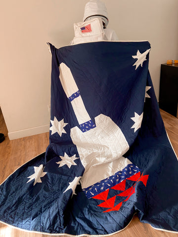 man in astronaut costume with custom space quilt